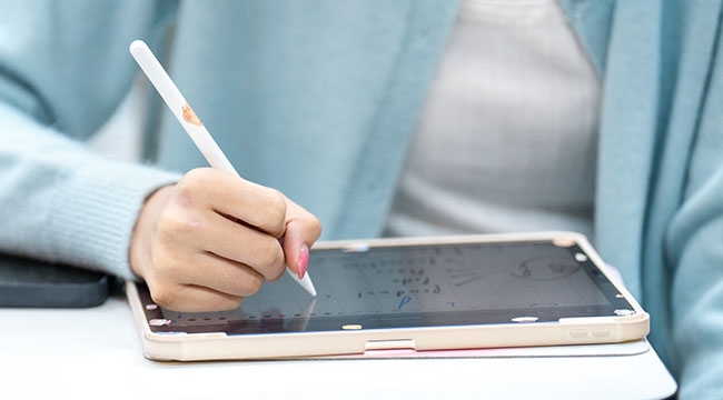 Person writing on a tablet